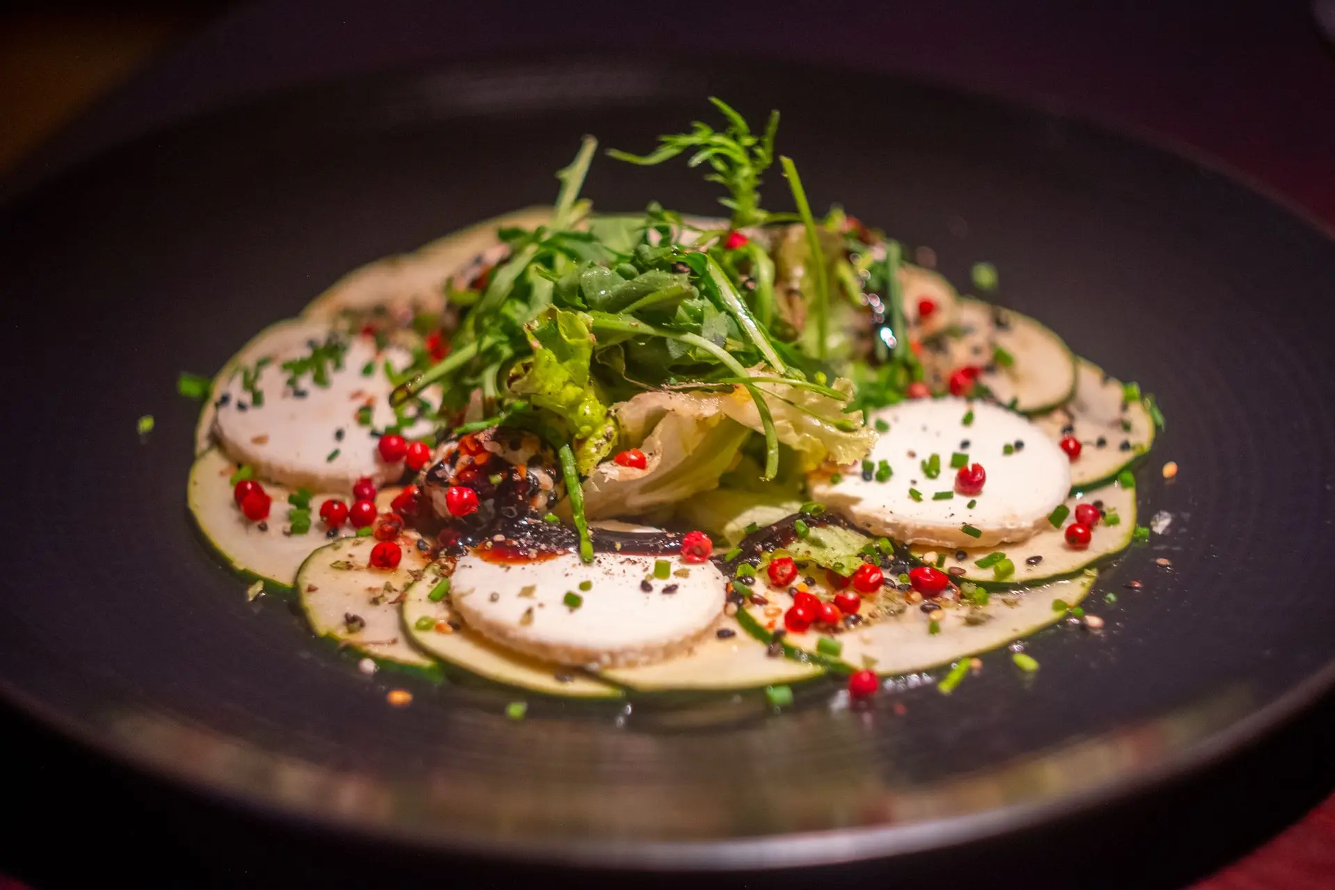 Este exquisito carpaccio de calabacín, delicadamente acompañado de queso de cabra fresco, hierbas aromáticas y un toque de aceite de oliva de calidad, es un homenaje a los sabores refinados del Mediterráneo. Capturado por Louis Mas, fotógrafo y videógrafo gastronómico en Barcelona, este plato vibrante es ideal para la identidad visual de restaurantes y campañas de marketing digital, destacando ingredientes frescos y de alta calidad en una presentación elegante.